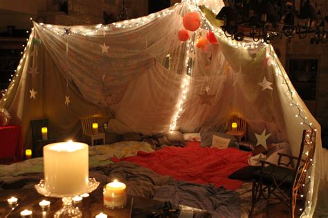 A Bed With Some Lights On It And Candles In Front Of The Bedspread