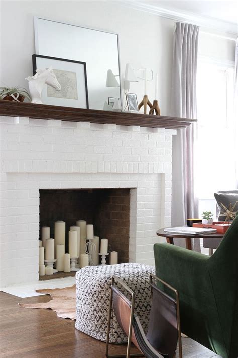 A hygge fireplace with lots of candles and greenery arrangements in beautiful vases for a natural feel. alternative-fireplace-decor-for-a-bold-statement-candles ...