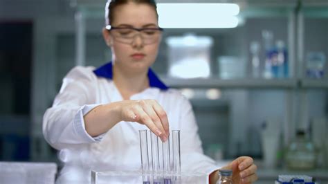 Woman scientist conducting research in chemical lab. Chemist mixing ...