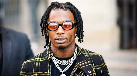 Playboi Carti Twisting Hair Is Wearing Black Yellow Overcoat And Silver