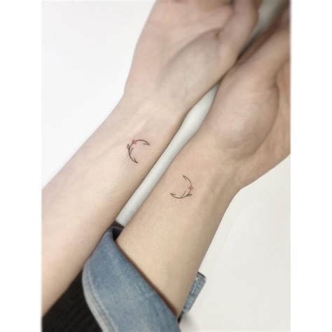 The wrist location of the best friends tattoos. Matching minimalist floral moon tattoos on the wrist.