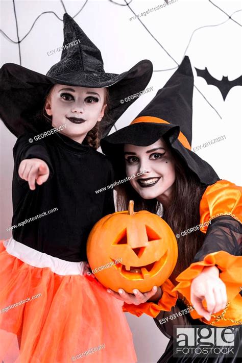 Children In Costumes Celebrating Halloween Against The Background Of