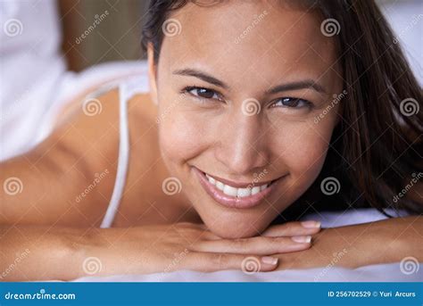 Happy That Its Finally Weekend Closeup Portrait Of A Beautiful Young Woman Lying On Her Bed