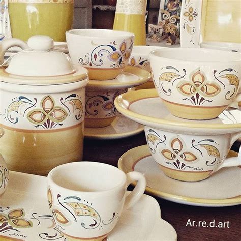 A Table Topped With Lots Of White And Yellow Dishes Covered In Saucers