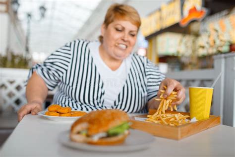 Grosse Femme Mangeant L hamburger à L espace Restauration De Mail Photo stock Image du