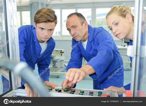 Engineer Showing Apprentices How To Operate Machine Stock Photo By