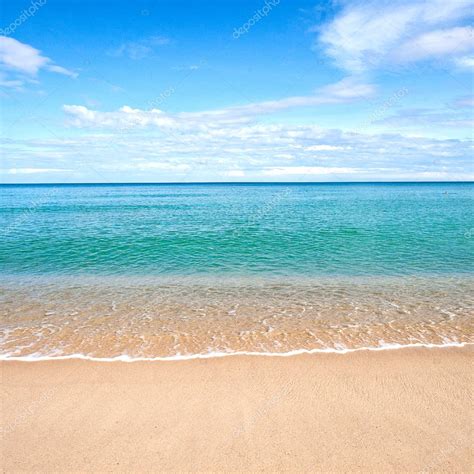 Beautiful Sandy Beach With Calm Water Against Blue Skies Stock Photo