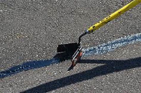 Filling Cracks With Hot Tar For Driveways Roads And Sports Courts