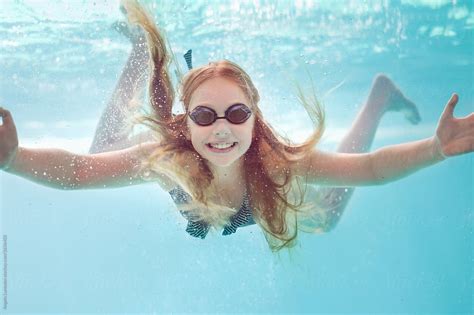 Smiling Girl With Swimming Goggles Underwater In A Pool By Stocksy Contributor Angela Lumsden