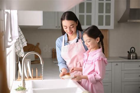 mother and daughter washing dishes together in kitchen stock image image of indoors dishes