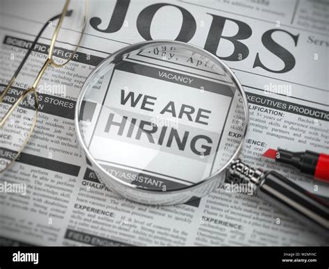 we are hiring job search and employment concept magnified glass with jobs classified ads in
