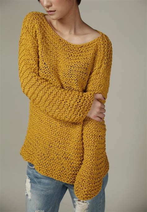A Woman With Short Hair Wearing A Yellow Knitted Sweater And Ripped