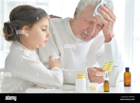Portrait Of The Granddaughter Takes Care Of A Sick Grandfather Stock