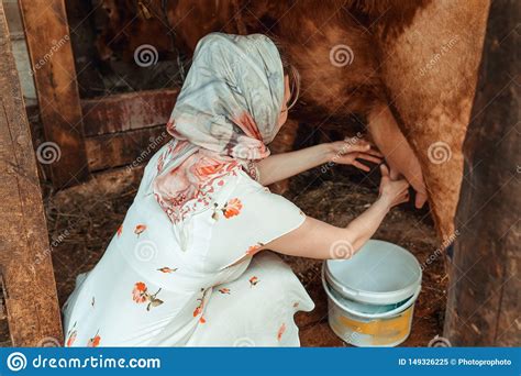 Woman Milkmaid And Man In Barn Working With Cow Milking Machines