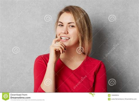 Happy Pleased Female Model Dressed In Red Clothes Looks With Confident