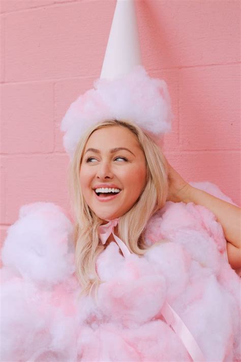 a woman in a pink dress and white hat is posing for the camera with cotton balls all around her