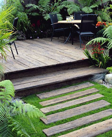 A Wooden Deck Surrounded By Lush Green Plants