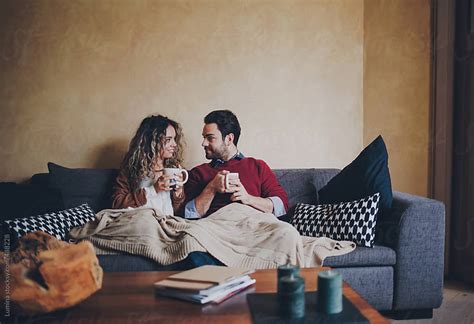 Happy Couple Drinking Tea In The Living Room By Lumina Stocksy United
