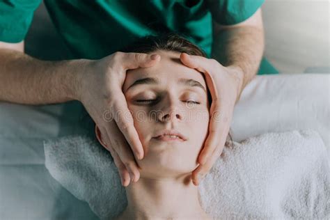 Male Massage Therapist Makes Face Massage To A Young Beautiful Woman Stock Image Image Of