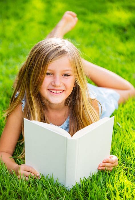 Cute Little Girl Reading Book Outside On Grass Stock Photo Image Of