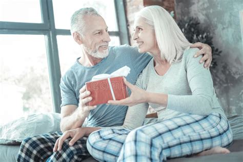 Attentive Caring Man Hugging His Wife Giving The Present Stock Image