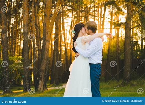 Close Up Portrait Of A Couple Of Newlyweds Standing In The Pine Forest