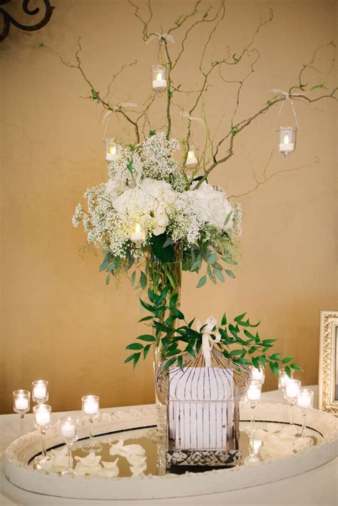 Rustic wedding centerpiece with dried flowers. Tall, White Flower-and-Branch Centerpiece With Hanging Candles