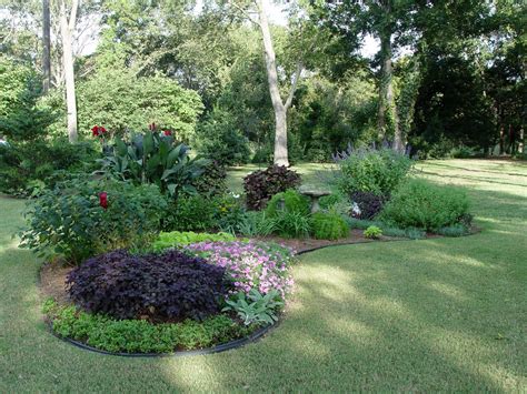 A colorful and tidy flower bed that lines hour house more than does the trick. Island bed | Lawn and garden, Front yard landscaping ...