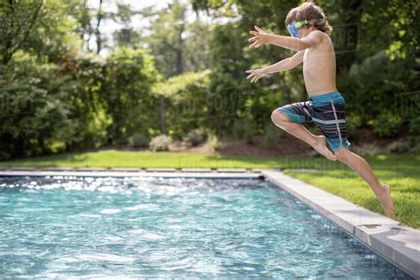 Boy Jumping Into Outdoor Swimming Pool Stock Photo Dissolve