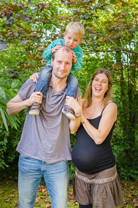 Familia Hermosa Feliz Con La Madre Embarazada En El Parque Foto De