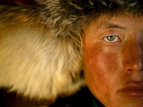 A Close Up Of A Person Wearing A Fur Hat And Looking At The Camera With