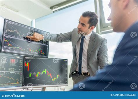 Stock Brokers Looking At Computer Screens Trading Online Stock Photo