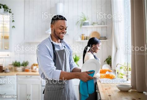 Cheerful Black Woman Washing Dishes While Her Husband Wiping Them At Kitchen Copy Space Stock