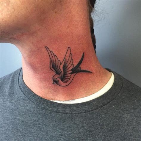 A Black And White Bird Tattoo On The Neck