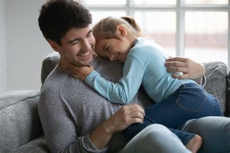 Close Up Happy Father And Little Daughter Cuddling On Couch Stock Image