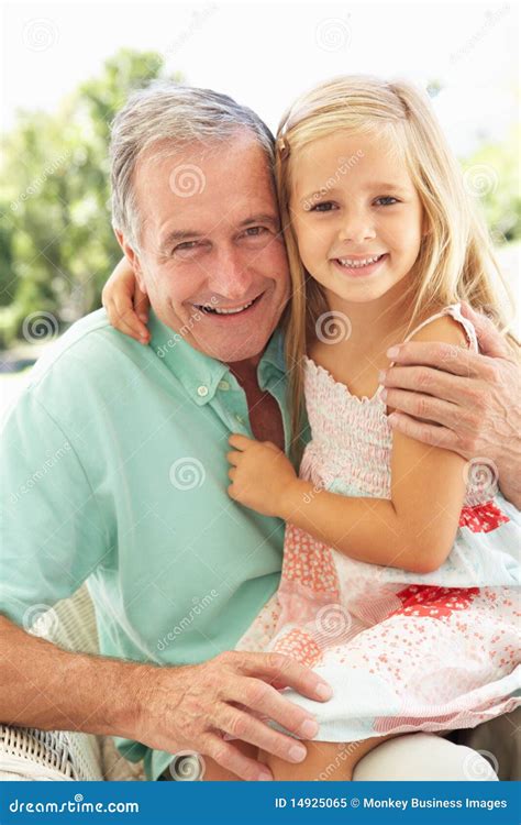 Grandfather And Granddaughter Garden Together In Backyard Stock Photo
