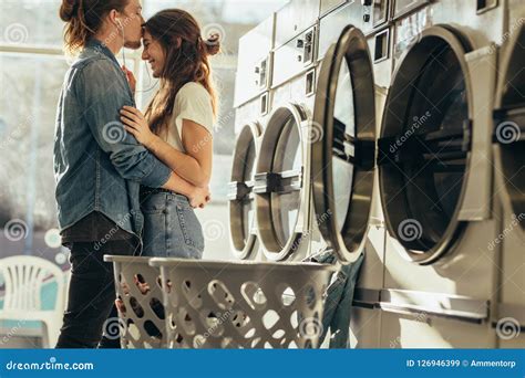 Man Kissing His Girlfriend On Forehead Standing In A Laundry Roo Stock Image Image Of