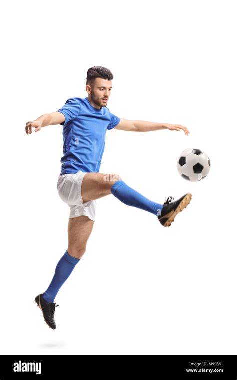 Jugador de fútbol saltando y pateando una pelota de fútbol aislado sobre fondo blanco Fotografía