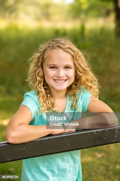 Girl With Curly Blonde Hair Smiling At Camera Stock Photo Download