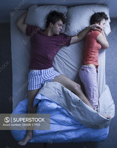 Man Stretched Out On Bed With Woman Sleeping Superstock