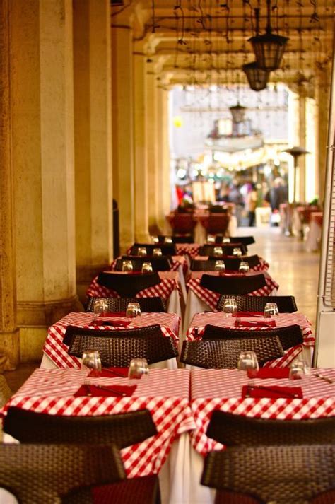 tables with red and white checkered cloths are lined up