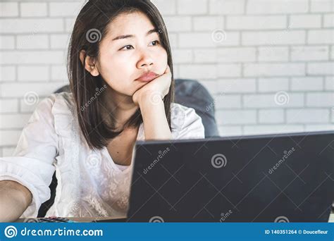 Unmotivated Asian Female Worker Sitting At Desk Bored To Work Stock