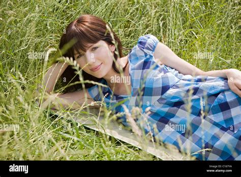 Young Dark Haired Woman Lying In Tall Grass Stock Photo Alamy