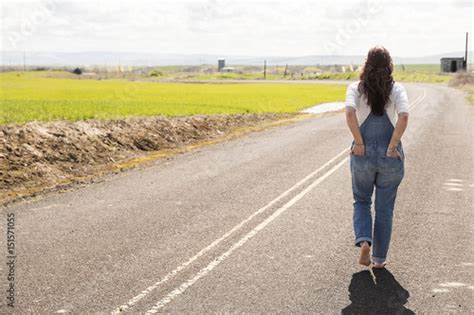 Barefoot Woman Walking Down A Quiet Country Road Stock Photo Adobe Stock