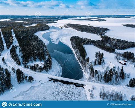 Aerial Top View Of Bridge Road Above Frozen River In Snow Winter