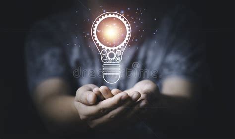 Hand Holding Glowing Lightbulb With Mechanical Gear Cog For Creative