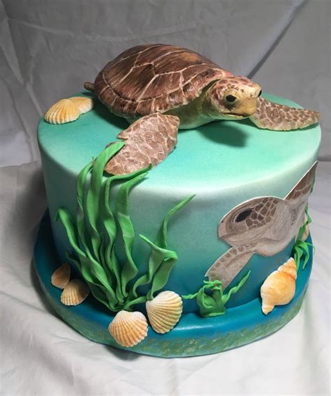 A Turtle Cake With Seaweed And Shells On It