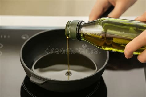 Woman Pouring Olive Oil Into Frying Pan On Stove Stock Photo Image Of