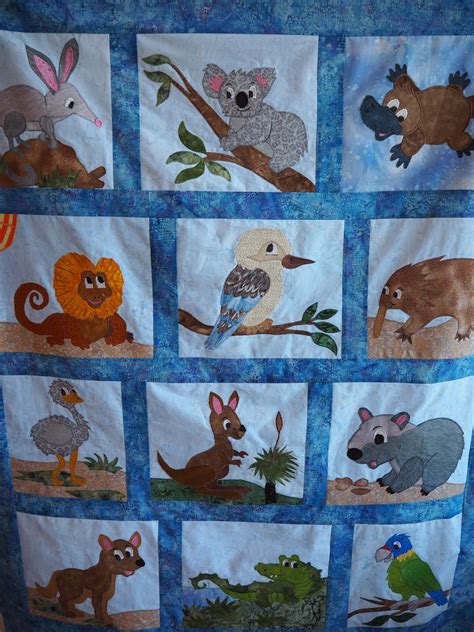 An Animal Themed Quilt Is Hanging On The Wall In Front Of A Bed Sheet