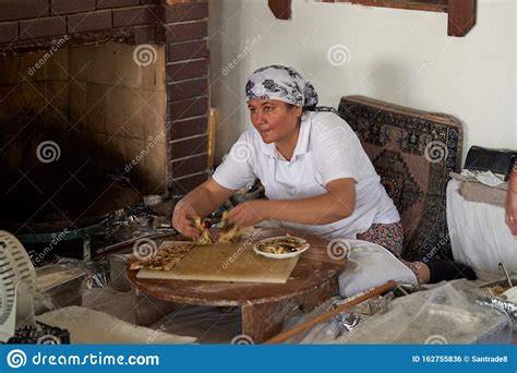 a woman cook in the traditional manual way bakes a turkish gozleme cake in an old oven